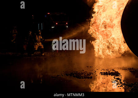 Feuerwehrmänner vom 23 d Bauingenieur Geschwader team Flammen während der Nacht, Live Fire Training, Jan. 10, 2017 zu löschen, bei Moody Air Force Base, Ga die Turboprop-maschinen Brände wurden durch Propangas Assistant Chief des Feuerwehr Training, Charlie Johnson. (U.S. Air Force Foto von Airman 1st Class Daniel Snider) Stockfoto