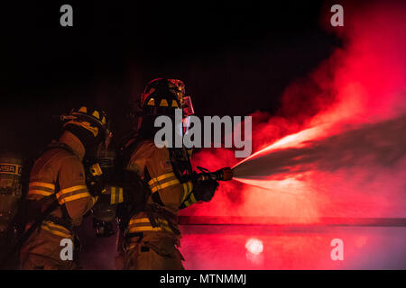 Feuerwehrmänner vom 23 d Bauingenieur Squadron Regenschauer ein prop Flugzeuge während der Nachtzeit, live Fire Training, Jan. 10, 2017, bei Moody Air Force Base, Ga. Diese Schulung ist eine jährliche Anforderung für Moody Feuerwehrmänner und ist nur eine der Möglichkeiten, die Sie bereit bleiben Menschen, Eigentum und Umwelt vor Brände und Katastrophen zu schützen. (U.S. Air Force Foto: Staff Sgt. Ryan Callaghan) Stockfoto