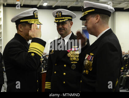 NAVAL BASE KITSAP - Bremerton, Washington (Jan. 12, 2017) - Kapitän Kevin Lenox, rechts, begrüßt Vice Adm. Mike Schuster, Kommandeur der Naval Air Forces, als Kapitän John Ring Uhren, was bedeutet, dass die Annahme der Pflichten als Kommandierender Offizier der Flugzeugträger USS Nimitz (CVN 68) bei einem Befehl Zeremonie. Ring beaufsichtigte die größte Arbeitspaket in einem geplante schrittweise Verfügbarkeit außerhalb der trockenen ausgeführt-Dock, sowie einem beschleunigten inter-Implementierung Schulung Zyklus während seiner Tour von 2014 bis 2017. Lenox Nimitz wird durch den Vorstand der Überprüfung und Besichtigung (INSURV) und Composite beaufsichtigen Stockfoto