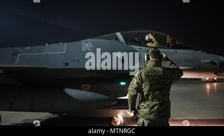 Kapitän David, 79th Expeditionary Jagdgeschwader Piloten, und Staff Sgt. Daniel Lasal, 455Th Expeditionary Aircraft Maintenance Squadron engagierte Crew Chief, einander grüßen, bevor eine Nacht mission Jan. 13, 2017 am Flughafen Bagram, Afghanistan. David trug in der Air Force im Jahr 2004 als F-16 Fighting Falcon Spezialist Avionik und jetzt fliegt der gleichen Zelle verwendete er ein Betreuer für zu sein. (U.S. Air Force Foto: Staff Sgt. Katherine Spessa) Stockfoto