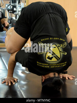 Command Sergeant Major Jill L. Crosby, Befehl Sergeant-Major, 1. Kavallerie Division entschlossene Unterstützung Sustainment Brigade, führt einen Schulterstand während ihrer Morgen-Yoga-Kurs in Bagram Airfield, Afghanistan. Crosby, aufgewachsen in Palm Beach, FL, begann Yoga zu tun, als eine Form der Rehabilitation nach Knie-OP, aber wie viele andere Soldaten es geistig findet und körperlich zu belohnen. Stockfoto