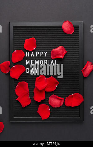 Schwarz mit weißem Kunststoff letterboard Briefe mit Zitat Happy Memorial Day, und Rosenblätter auf dem schwarzen Hintergrund. Stockfoto