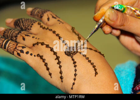 Frau Zeichnung mehendi oder Tätowierung auf ihre eigene Hand Stockfoto
