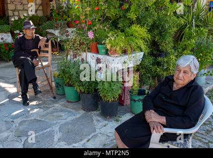 Ein älteres Ehepaar im Schatten sitzen in Omodos Dorf, Zypern Stockfoto