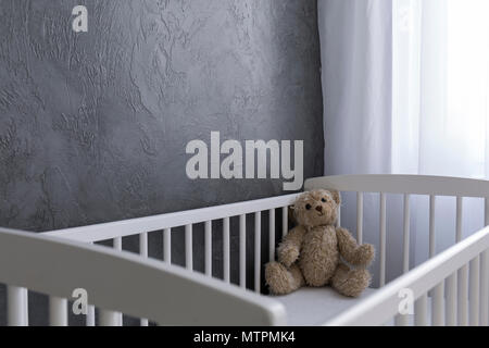 Der Teddybär sitzen in einer Krippe Stockfoto