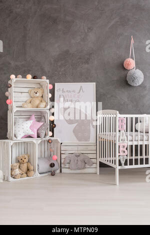 Geschossen von einem grauen Baby Zimmer mit einem Kinderbett, Boxen und Teddybären Stockfoto