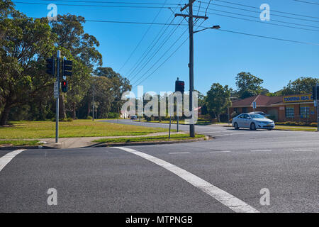 Eine Kreuzung bei Toormina mit Ampel zeigt rot und ein Taxi an der Kreuzung warten, New South Wales, Australien Stockfoto