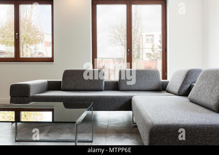 Großes und bequemes Sofa stand in hellen Interieur mit Windows Stockfoto