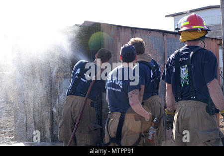 Mitglieder der Altus Feuerwehr, was von der Feuer auf den Schuppen links, Jan. 24, 2017, in der Stadt von Altus Oklahoma. Die Wildfire wurde mit den gemeinsamen Anstrengungen von Altus Air Force Base und der Stadt von Altus Feuerwehr stellen, halten die Base und lokalen Zivilisten sicher. Stockfoto