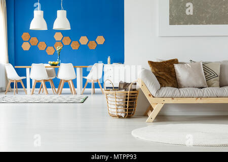 Holz- und natürliche Ausstattung der gemütlichen Hängeboden innen mit Kork fliesen Dekoration, beige Sofa, Kissen, Malerei und Essbereich Stockfoto