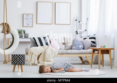 Süße Mädchen im Kleid lag auf dem Boden in der modernen scandi Zimmer Stockfoto