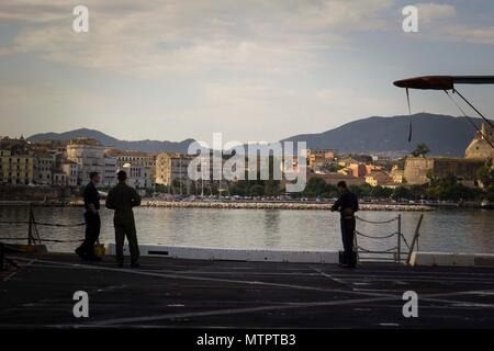 Korfu, Griechenland (21. Mai 2018) Marinesoldaten und Matrosen an Bord der San Antonio-Klasse amphibious Transport dock USS New York (LPD 21) die Skyline beobachten, wie das Schiff fährt Korfu, Griechenland, 21. Mai 2018, nach einer geplanten Hafen besuchen. New York, seit der Abreise seinen Heimathafen von Mayport, Florida, hat eine nach vorn naval Präsenz, unterstützt Maritime Security Operations, Krisenbewältigung und Theater die sicherheitspolitische Zusammenarbeit in Europa, Afrika und dem Nahen Osten Theater. (U.S. Marine Corps Foto von Cpl. Juan A. Soto-Delgado/Freigegeben) Stockfoto