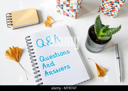 Q&A - Fragen und Antworten in einem Notebook auf weißem Tabelle geschrieben Stockfoto