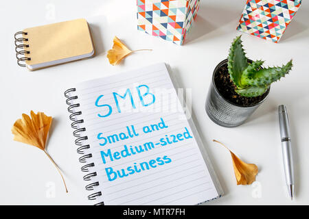 SMB Small And Medium-sized Business written in a notebook on white table Stockfoto