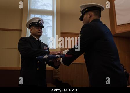 170120-N-BR087-086 BREMERTON, Washington (20. Januar 2017) Chef Logistik Spezialist Marcusallen Burdios, Long Beach, Kalifornien, geht die amerikanische Flagge, Senior Chief Boatswain Mate Long Nguyen, aus Tacoma, Washington, bei seiner Pensionierung Zeremonie. Familie, Freunde und Segler aus USS John C. Stennis (CVN-74) nahmen an der Zeremonie zu Ehren Nguyens 24 Jahre des naval Service. John C. Stennis ist derzeit in Vorbereitung für eine geplante inkrementelle Verfügbarkeit Hafen. (Foto: U.S. Navy Mass Communication Specialist 3. Klasse Cole C. Pielop / veröffentlicht) Stockfoto