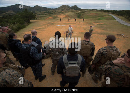 Schüler beobachten wie ihre Lehrer mit der Mossberg 12 Gage Schrotflinte während der nicht-tödliche Waffen Instructor Kurs auf Lager Hansen, Okinawa, Japan präsentiert. Marines, Matrosen, Piloten und japanischen Wachpersonal füllen Sie eine Woche lang nichttödliche Instructor Kurs Waffen welche überdachte Taser Training, OC Belichtung und Riot Teamtaktik steuern. (Foto: U.S. Marine Corps MCIPAC Bekämpfung der Kamera Lance Cpl. Brooke Deiters) Stockfoto