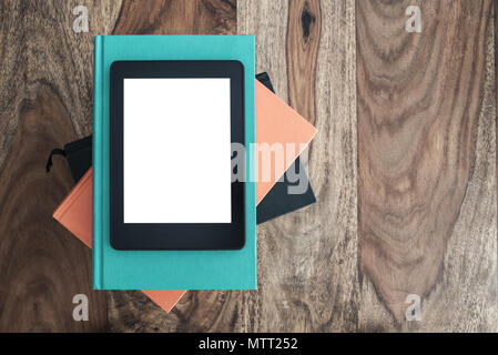 Blick von oben auf die e-book reader auf Stapel der Bücher auf dem Holztisch Stockfoto