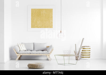 Golden Plakat, auf weißer Wand über Holz- Couch in helles Wohnzimmer mit Fußstütze und Körbe Stockfoto