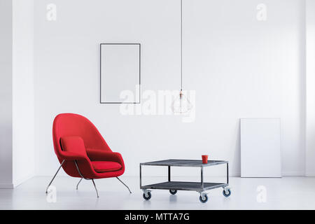 Weiße Zimmer mit Metall Tisch, roten Sessel und zwei mockup Poster Stockfoto