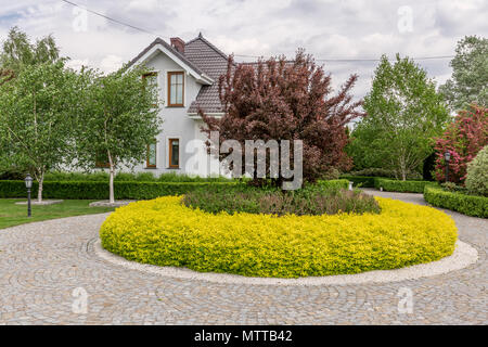 Hinterhof einer neuen Stil Villa mit einem Stein Pfad und dekorativen Pflanzen Stockfoto