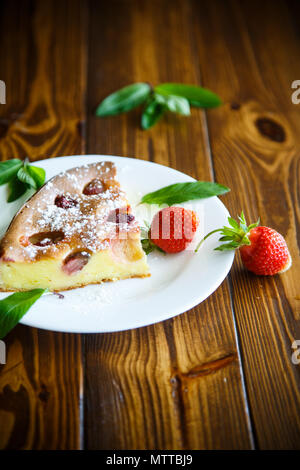 Hüttenkäse süßer Auflauf mit Erdbeeren auf einem Holztisch Stockfoto