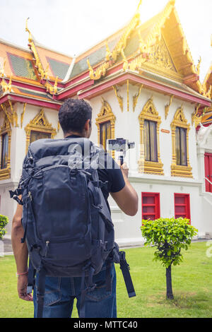Mann backpacher Wer hält Mobiltelefon auf Gimbal Besuch in Asien an einem sonnigen Tag, Solo Reise und Ferien Konzept. Stockfoto