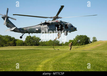 Der Sikorsky MH-60S Sea Hawk ist ein zweimotoriger Turbowellen-Nutzhubschrauber der United States Navy. Am 24. Mai 2018 wurde ein Techniker der Ordnance Disposal Group 2 von einer MH-60S, die der Helicopter Sea Combat Squadron 7 während einer Luftfahrzeugdemonstration in Bridgewater, New Jersey, für die Flottenwoche New York 2018 zugewiesen wurde, mit Schnellseilen versorgt. Das Archivbild dokumentiert die vertikale Einfügetechnik über einem Schulfeld. Stockfoto