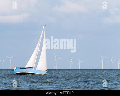 Menschen auf Segelboot Segeln auf dem IJsselmeer und Windenergieanlagen des Windparks Urk, Niederlande Stockfoto