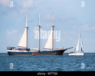 Authentischen Segelschiff, Schoner, ganz in der Nähe von kleinen Segelboot auf dem IJsselmeer, Niederlande Segeln Stockfoto