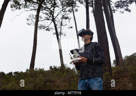 Mann Betrieb einer Flying drone bei der Verwendung von Virtual reality Headset Stockfoto