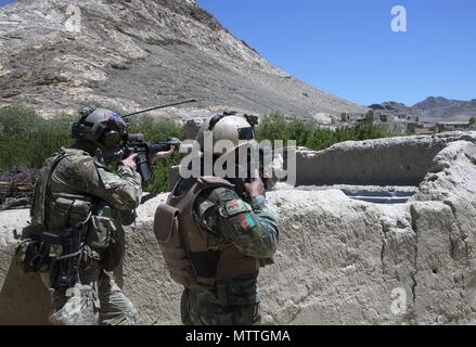 SAYYIDABAD BEZIRK, Afghanistan (24. Mai 2018) - Ein afghanischer Commando vom 8 Special Operations Kandak und eine US-Special Forces Soldat den Horizont für feindliche Bewegung während einer Operation scan Taliban-führung in Sayyidabad Bezirk zu finden, der Provinz Wardak, Afghanistan, 24. Mai 2018. Die Kommandos erfolgreich gelöscht Verbindungen von Interesse und entfernte feindliche Kämpfer und Waffen vom Schlachtfeld, verschlechtert sich die Fähigkeit der Taliban zu leiten - Profil Angriffe in und um Kabul. (U.S. Armee Foto von Sgt. Paul Verkauf) Stockfoto