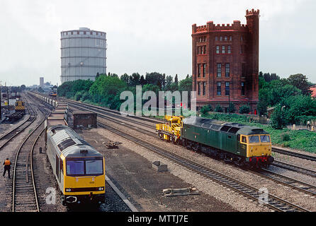 Eine Klasse 60 diesel Lok60006' Great Gable" wartet mal in Southall Hof mit einem Rake von leeren Stein Trichter als Class 47 diesel Lok 47484 "Isambard Kingdom Brunel" geht mit einem Zusammenbruch Kran im Schlepptau. August 1992 21. Stockfoto