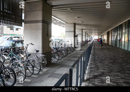 Kyoto, Japan - 24. Juli 2016. Straße in Kyoto an einem Sommertag im Juli, Menschen zu Fuß auf dem Gehweg, sichtbaren Parkplatz für Fahrräder. Stockfoto