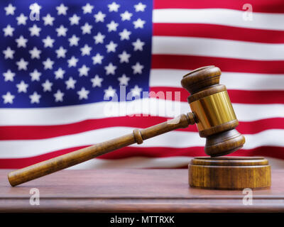 Eine hölzerne Hammer ruht auf einem Richter Sitzbank mit der amerikanischen Flagge im Hintergrund. Stockfoto