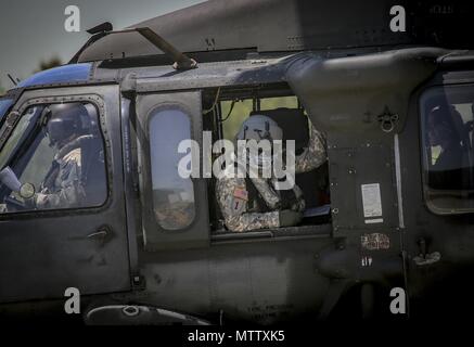 New Jersey Army National Guard Staff Sgt. John Panepinto, ein UH-60L Black Hawk helicopter Crew Chief vom 1 Assault Helicopter Bataillon, 150 Aviation Regiment sitzt in der gunner Sitz für einen Flug am Joint Base Mc Guire-Dix - Lakehurst, N.J. Mai 15, 2018, 15. Mai 2018. (U.S. Air National Guard Foto von Master Sgt. Matt Hecht). () Stockfoto