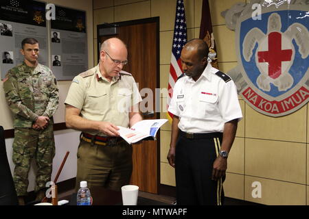 HONOLULU, Hawaii - (Jan. 25, 2017) Regionale Gesundheit Command-Pacific Kommandierender General, Brig. Gen. Bertram Vorsehung als Vereinigtes Königreich Verteidigungsministerium Führungskraft, der Direktor der medizinischen Politik, der Betrieb und die Fähigkeit, britischer Generalmajor Martin Bricknell ihm Geschenke mit einer Reihe von Zeitschriften aus dem Royal Army Medical Corps und dem Ministerium für Verteidigung. Der Austausch folgte eine globale Gesundheit Engagement wie RHC-P und Vereinigtes Königreich militärischen medizinischen Vermögenswerte, die vietnamesischen Ministerium für Verteidigung durch Gegenstand des Austauschs in der Vergangenheit engagiert haben und auch projiziert, Stockfoto