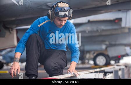 170127-N-YL 257-035 ATLANTIK (Jan. 27, 2017) Aviation Boatswains Mate (Handling) Flieger Alex Gonzales scheuert sich die Kante der Flight Deck an Bord der USS George H.W. Bush (CVN 77). Der Flugzeugträger mit der George H.W. bereitgestellt Bush Carrier Strike Group zur Unterstützung der Maritime Security Operations und Theater Sicherheit Zusammenarbeit in den USA am 5. und 6 Flotte Arbeitsgebiete. (U.S. Marine Foto von Mass Communication Specialist 3. Klasse Christopher Gaines/Freigegeben) Stockfoto