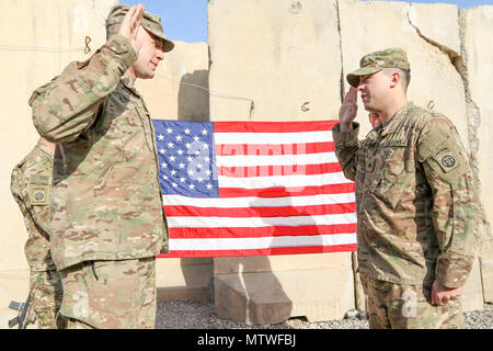 Oberstleutnant John Hawbaker, Kommandant der 1. Staffel, 73 Cavalry Regiment, 2nd Brigade Combat Team, 82nd Airborne Division, Fragen nach dem Eid des reenlistment zu Sgt. Patrick R. Bradford, ein infanterist, nach seiner dreijährigen reenlistment bei Qayyarah West, Irak, Jan. 26, 2017. Zur Unterstützung der Operation inhärenten lösen, die 2 BCT eingesetzt, 82. Abn. Div. ermöglicht, ihre irakische Sicherheitskräfte, die Partner durch den beraten und unterstützen die Mission, die die Planung, Erfassung und Analyse von Intelligenz, Kraft und Präzision Brände die militärische Niederlage der ISIL zu erreichen. (U.S. Armee Foto von St Stockfoto