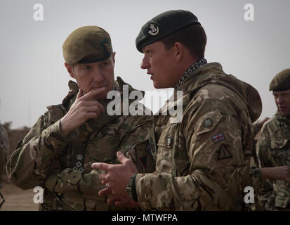 Ein britischer Trainer Schriftsatz britischen Brig. Gen. Zac Stenning, Links, Kommandant der 1. Gepanzerten Infanterie Brigade, auf irakische Sicherheitskräfte den Trainingsfortschritt bei Al Asad Air Base, Irak, Jan. 26, 2017. Britische Soldaten stellen die irakischen Sicherheitskräfte Training durch die Combined Joint Task Force - inhärenten Building Partner Kapazität mission Lösen. CJTF-OIR ist die globale Koalition zu besiegen ISIL im Irak und in Syrien. (U.S. Armee Foto von Sgt. Lisa Soja) Stockfoto