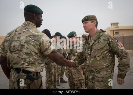 Britische Brig. Gen. Zac Stenning, rechts, Kommandant der 1. Gepanzerten Infanterie Brigade, schüttelt Hände mit einem Britischen Soldaten während einer Moral und Tierschutz Besuch im Al Asad Air Base, Irak, Jan. 26, 2017. Britische Soldaten stellen die irakischen Sicherheitskräfte Training durch die Combined Joint Task Force - inhärenten Building Partner Kapazität mission Lösen. CJTF-OIR ist die globale Koalition zu besiegen ISIL im Irak und in Syrien. (U.S. Armee Foto von Sgt. Lisa Soja) Stockfoto