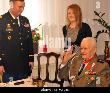 Polnischen Armee pensionierter Oberstleutnant Jan Kudla, ein WW II Veteran, hebt seine Hand zu grüßen Brig. Gen. Stanislaw Czosnek (nicht abgebildet), Kommandant der 11 gepanzerte Kavallerie Division während Oberst Christopher Norrie, Kommandant der 3. Gepanzerten Brigade Combat Team, 4 Infanterie Division blickt auf während ihres Besuchs in kudla's Home 31.01.2017, Zielona Gora, Polen. Kudla trat der polnischen Armee als Offizier in 1941 und in den Schlachten in Frankreich, Deutschland, Belgien und den Niederlanden kämpften während des Zweiten Weltkrieges. Für seine Tapferkeit während des Krieges war er das Kreuz der Tapferkeit, das entspricht der Legio ausgezeichnet Stockfoto