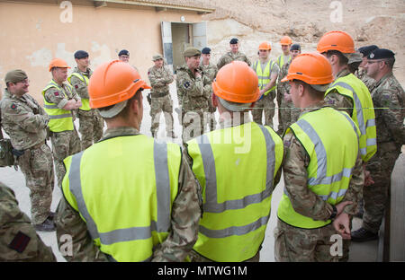 Britische Brig. Gen. Zac Stenning, Mitte, Kommandant der 1. Gepanzerten Infanterie Brigade, trifft sich mit britischen Soldaten aus dem 4. Bataillon, "Die Gewehre", während eine Moral und Tierschutz Besuch im Al Asad Air Base, Irak, Jan. 26, 2017. Britische Soldaten stellen die irakischen Sicherheitskräfte Training durch die Combined Joint Task Force - inhärenten Building Partner Kapazität mission Lösen. CJTF-OIR ist die globale Koalition zu besiegen ISIL im Irak und in Syrien. (U.S. Armee Foto von Sgt. Lisa Soja) Stockfoto