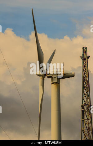 In der Nähe von Windenergieanlagen in einem Windpark gegen einen klaren blauen Himmel Erzeugung alternativer Energie Stockfoto