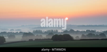 Nebliger Sonnenaufgang im Frühjahr über die Landschaft von Warwickshire in der Nähe von Stratford-upon-Avon. Warwickshire, Großbritannien. Panoramablick Stockfoto