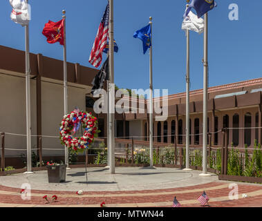 Memorial Day Blumen und Fahnen im Gedenken der gefallenen Veteranen. Memorial fertiger Steine am Veterans Memorial Plaza, Campbell, Kalifornien, USA. Stockfoto