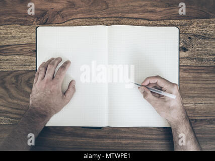 Blick von oben auf die Menschen der die Feder im Tagebuch oder Notepad auf Holztisch zu schreiben Stockfoto