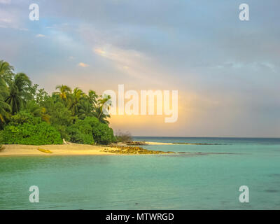 Sonnenuntergang über dem tropischen Meer und Coral Beach mit bunten Wolken im Himmel. Boote am Horizont. Nord Male Atoll Asdu, Indischer Ozean. Stockfoto