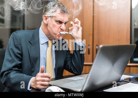 Porträt eines nervösen Geschäftsmann rauchen viele Zigaretten auf einmal Stockfoto