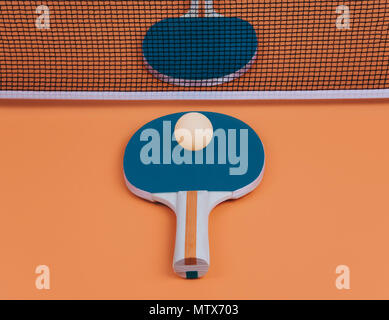 Tischtennis oder Ping pong Schläger und Bälle auf eine orange Tabelle. Stockfoto