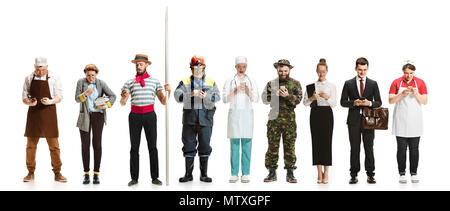 Collage aus verschiedenen Berufen. Gruppe von Männern und Frauen in Uniform stehend an Studio mit Telefon isoliert auf Weiss. Volle Länge von Menschen mit unterschiedlichen Stockfoto